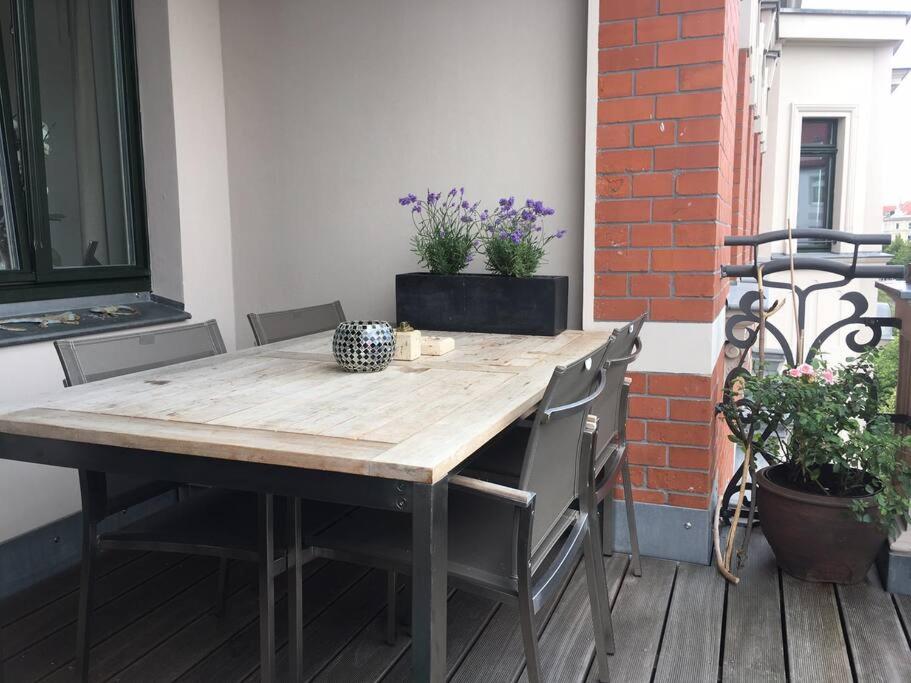 einen Holztisch und Stühle auf einer Terrasse in der Unterkunft Tolle Designer Wohnung in der Südvorstadt in Leipzig