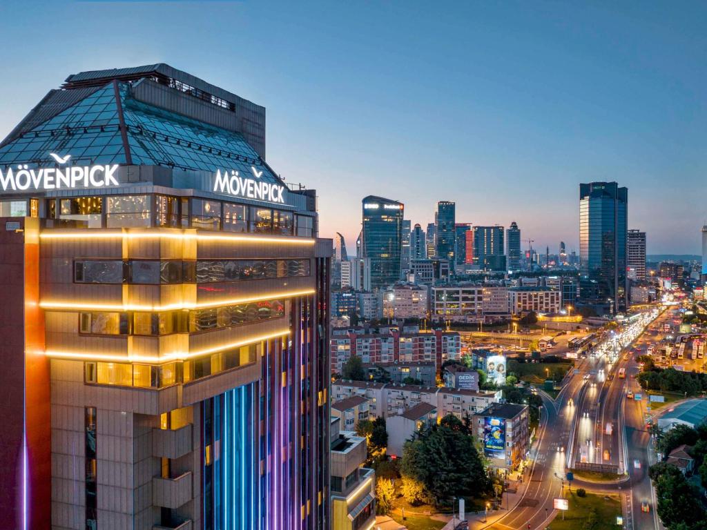 Mövenpick Hotel Istanbul Bosphorus في إسطنبول: اطلالة على مدينة في الليل مع مبنى