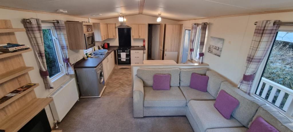 a living room with a couch and purple pillows at Holiday Caravan at Beauport in Hastings