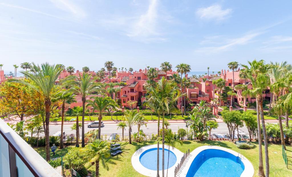 widok na ośrodek z palmami i basenem w obiekcie Beachside Apartment With Sea View w mieście Estepona