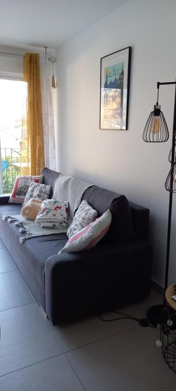 a couch in a living room with pillows on it at les campanules in Bourg-Saint-Maurice