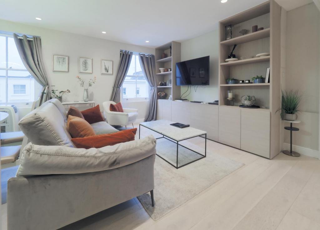 un soggiorno con divano e tavolo di Luxury 3 Bedroom Flat in Maida Vale a Londra