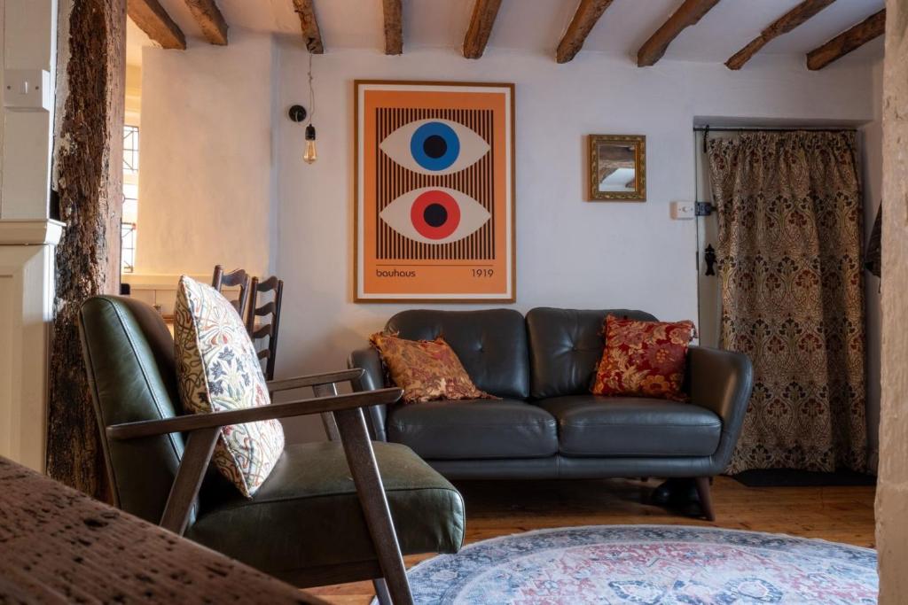 a living room with a couch and an eye picture at Fishermans Cottage built in 1705 in Hastings