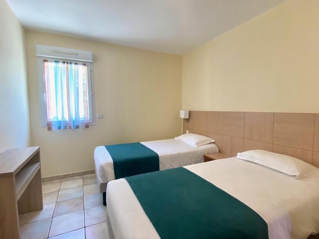 Postel nebo postele na pokoji v ubytování Calvi Résidence, Appart'hôtel
