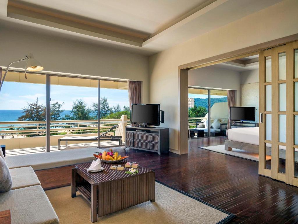 a living room with a room with a view of the ocean at Pullman Phuket Karon Beach Resort in Karon Beach