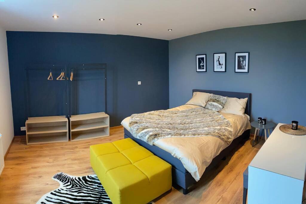 1 dormitorio con cama y pared azul en La Maison Blanche en Namur