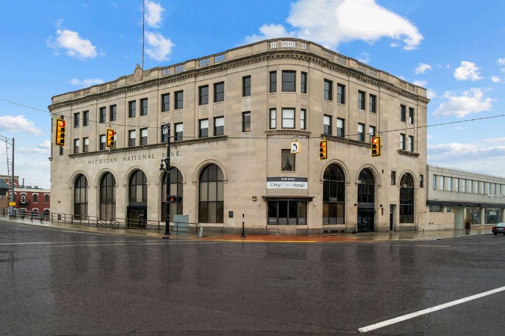 a large stone building on a street corner with a traffic light at CityFlatsHotel - Port Huron, Ascend Hotel Collection in Port Huron
