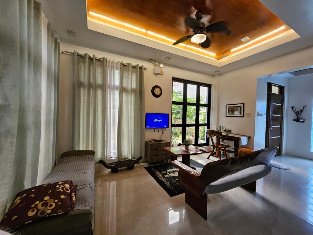 a living room with a couch and a ceiling fan at Andrew n Sophia's Guest House in Puerto Princesa City