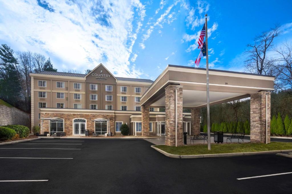 un hotel con bandera americana en un estacionamiento en Country Inn & Suites by Radisson Asheville Downtown Tunnel Road, en Asheville