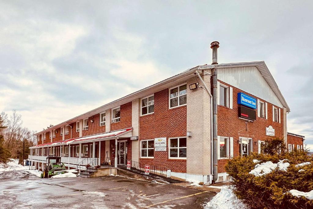 un gran edificio de ladrillo rojo en la nieve en Rodeway Inn, en Woodstock