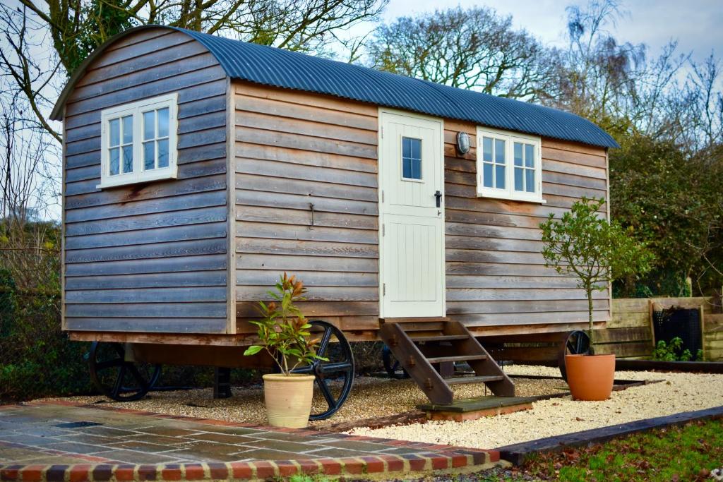 Cabaña de madera pequeña con puerta y ventanas en The Deer Hut en Burpham