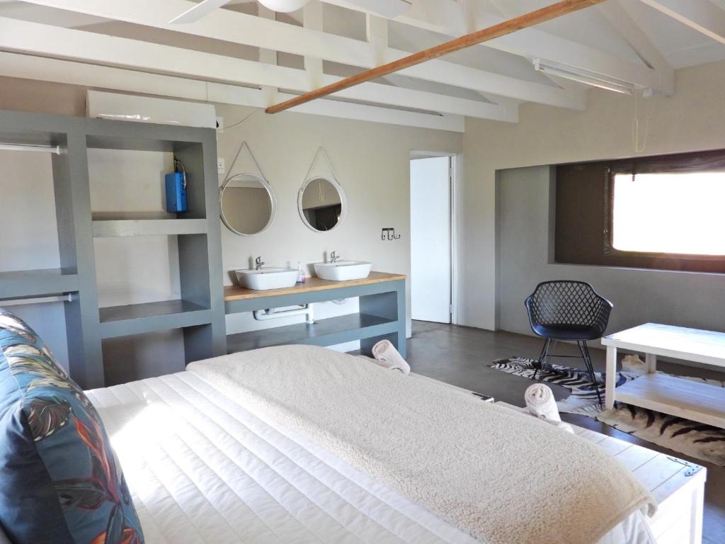 ein Schlafzimmer mit einem großen Bett und einem Schreibtisch in der Unterkunft Newburg Lodge & Luxury Bush Tents, Elements Private Golf Reserve in Moheme