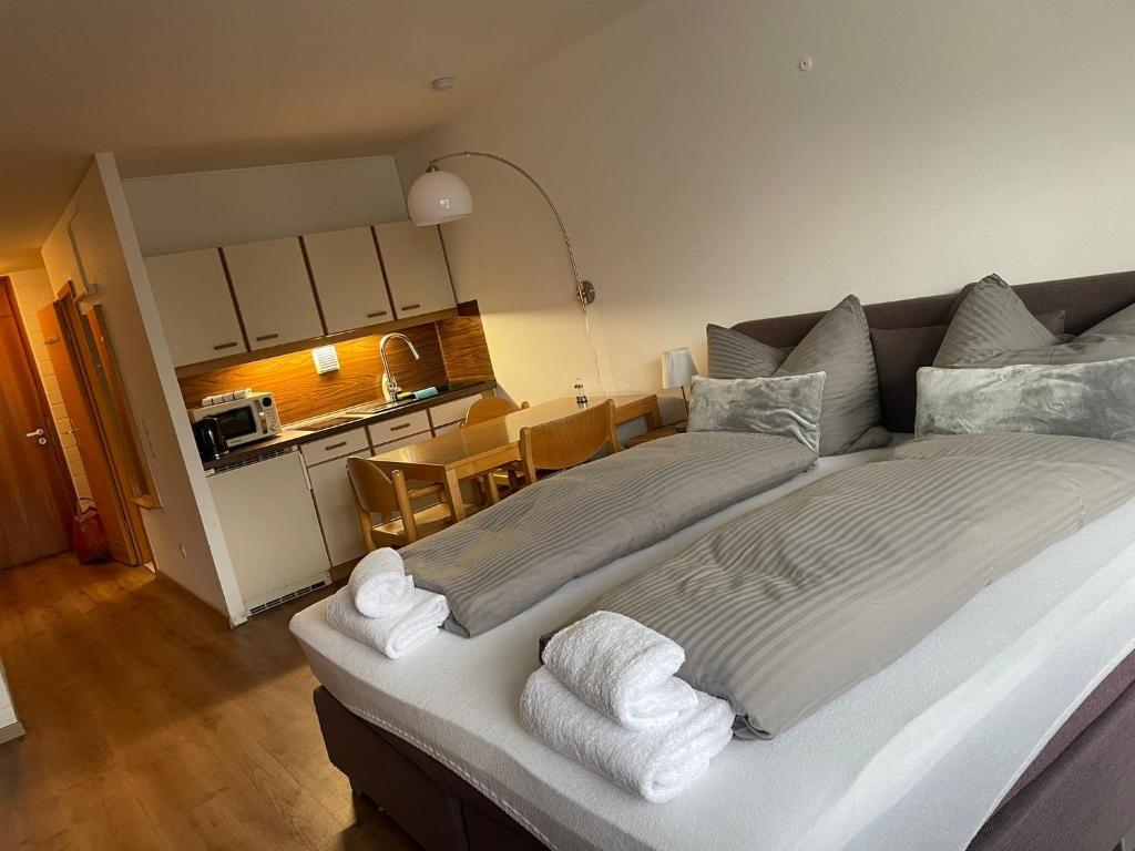 een slaapkamer met een groot bed en handdoeken bij Pleskini Apartments in Sankt Englmar