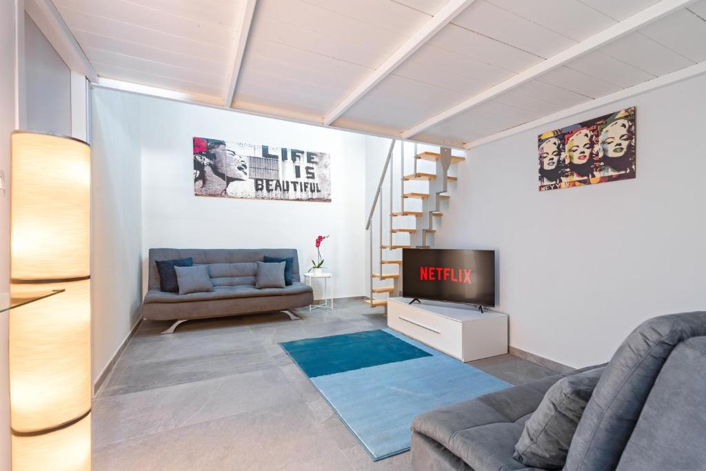 Exclusive Loft - Life is Beautiful - Free WiFi - 5 min To Metro Nizza في تورينو: غرفة معيشة بها أريكة وتلفزيون