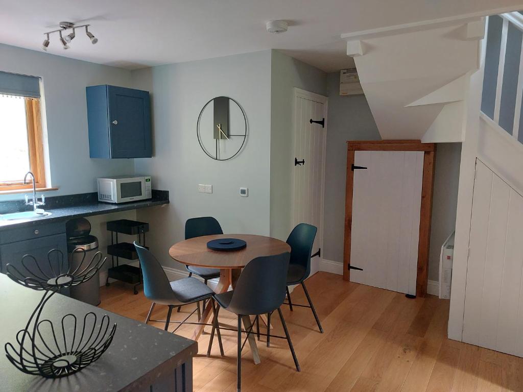 a kitchen and dining room with a table and chairs at The Hen Den in Hopton Cangeford