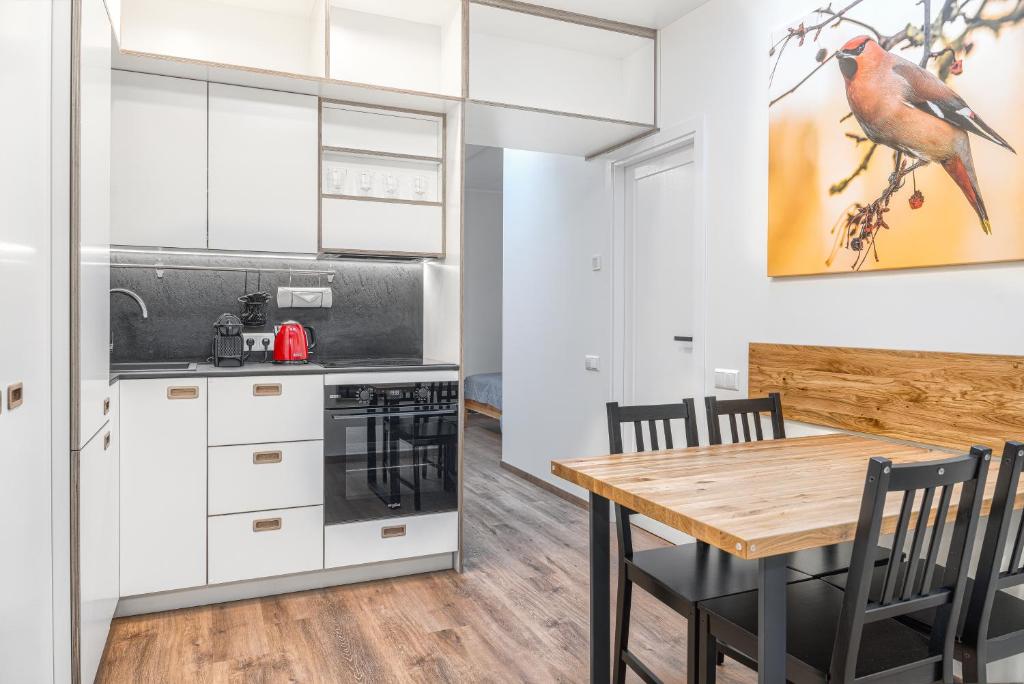 a kitchen and dining room with a wooden table and chairs at TopFloor Apartments in Vilnius