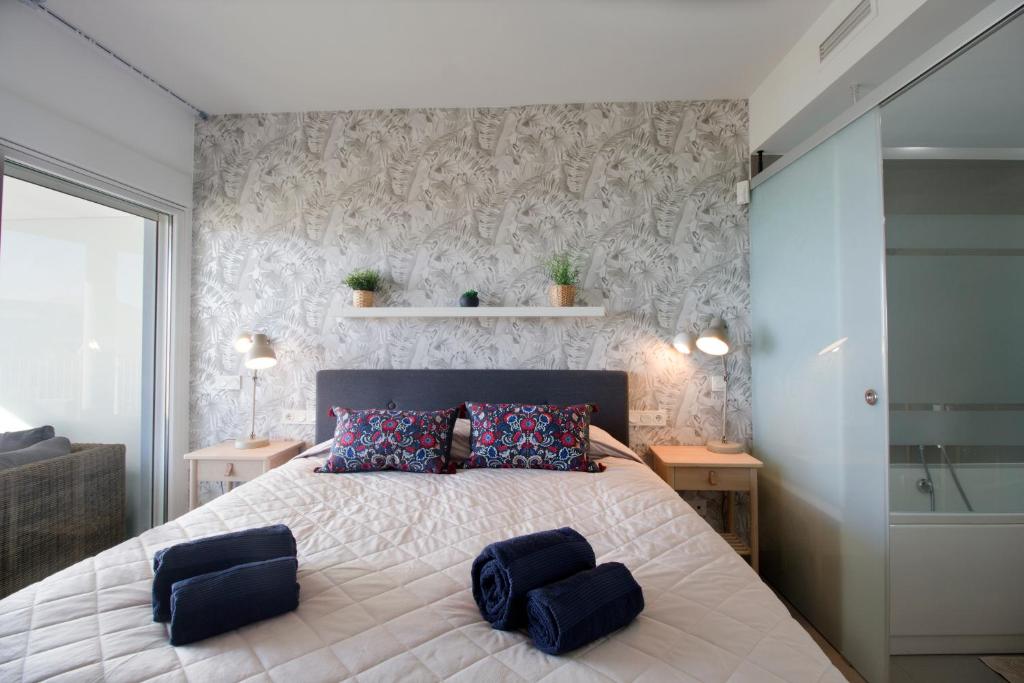 um quarto com uma cama grande com dois bancos em Luxury Apartment With Sea View em Benalmádena