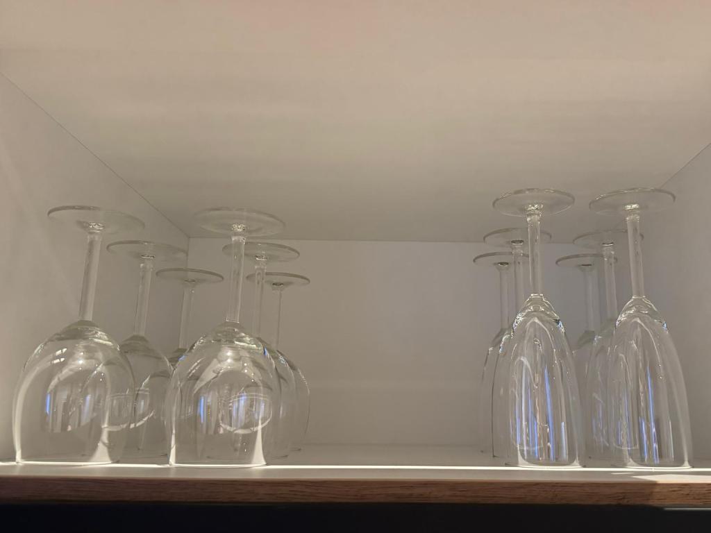 a row of wine glasses sitting on a shelf at Belm Ferienwohnung am Bach in Belm