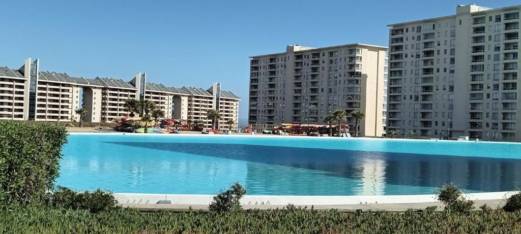 une grande piscine en face de certains bâtiments dans l'établissement Complejo Laguna bahía Sol, à Algarrobo
