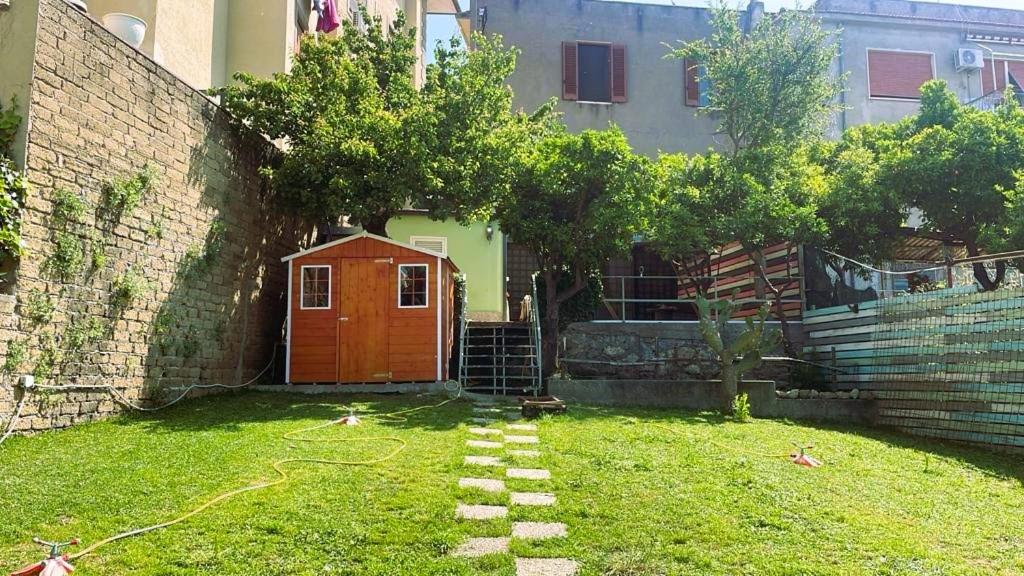 um jardim com uma porta vermelha na relva em La casa di Judy e Frank em Tarquinia