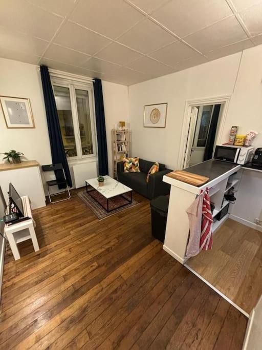 a living room with a couch and wooden floors at Appartement cosy proche métro in Ivry-sur-Seine