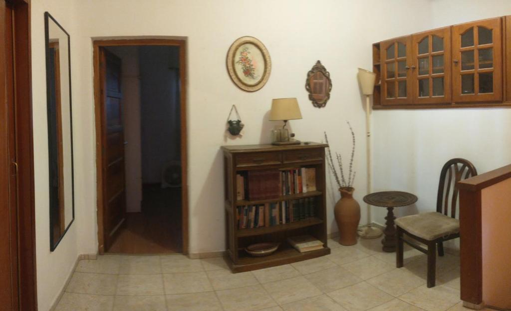 Departamento centro Boj في Deán Funes: غرفة معيشة مع رف كتاب ومصباح