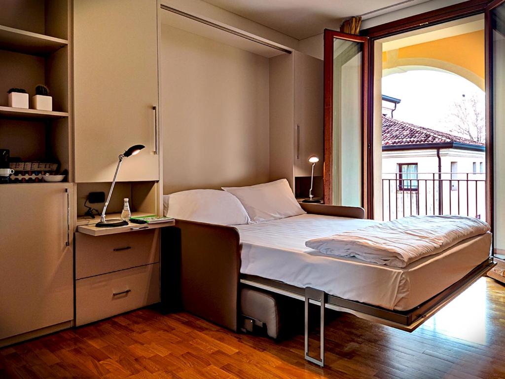 a bedroom with a bed and a large window at Hotel Villa Dei Carpini in Oderzo