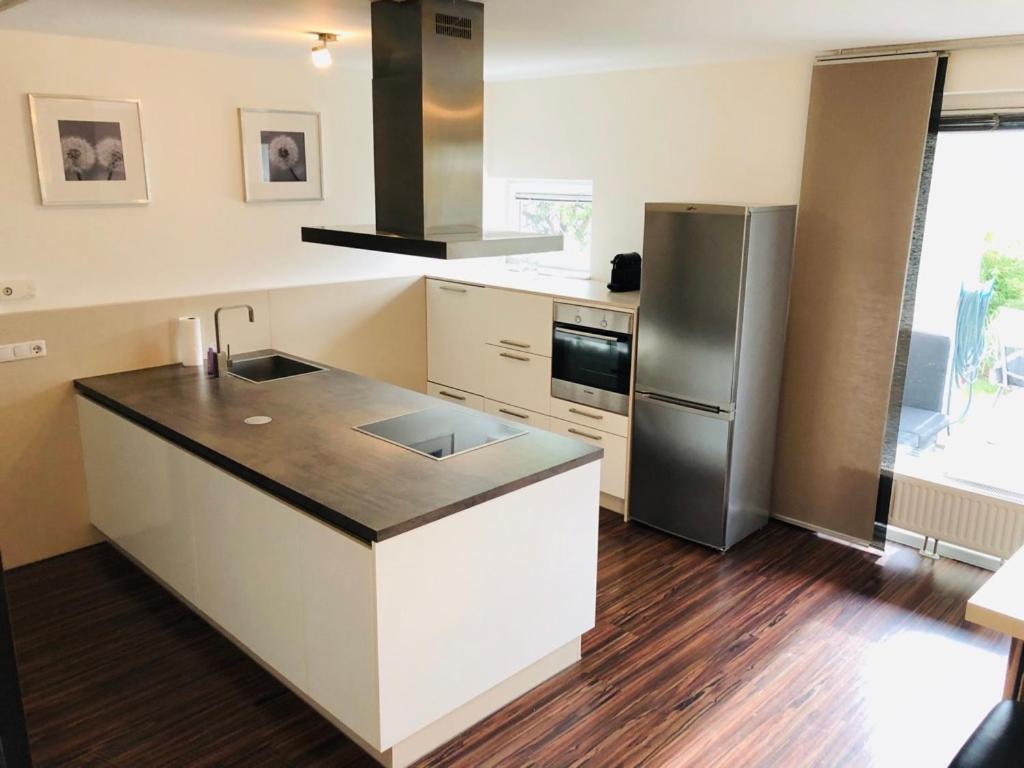 a kitchen with a refrigerator and a counter top at 25h GARDEN Apartment PLUS private Beach in Neusiedl am See