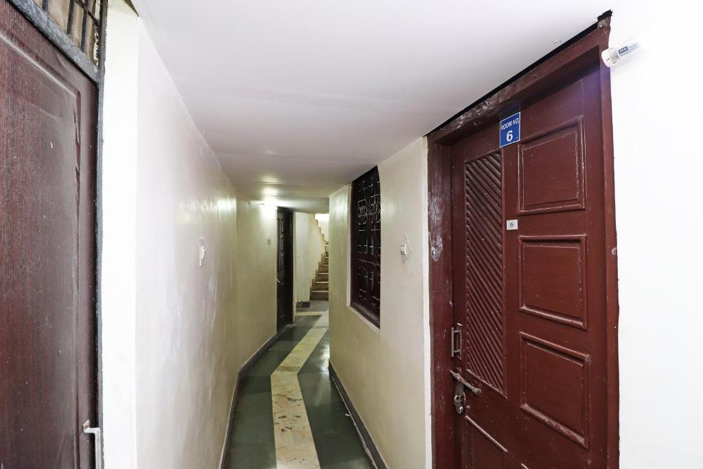 an empty hallway with two brown doors and stairs at Hotel Kshama in Jabalpur