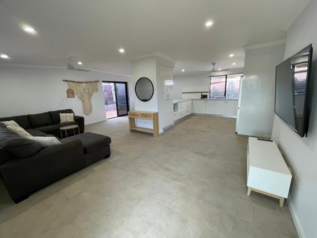 a large living room with a couch and a kitchen at Carpenter House in Exmouth