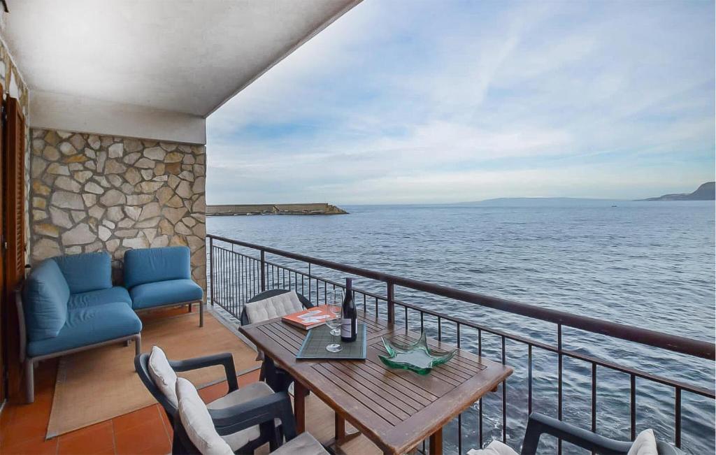 a balcony with a table and chairs and the ocean at Amazing Apartment In Scilla With Wifi in Scilla