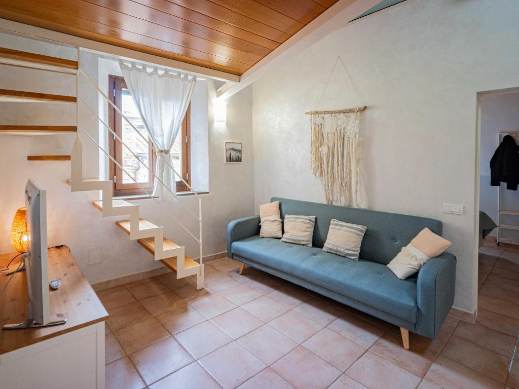 a living room with a blue couch and a staircase at Casa Giulia - Appartamento a San Gimignano in San Gimignano