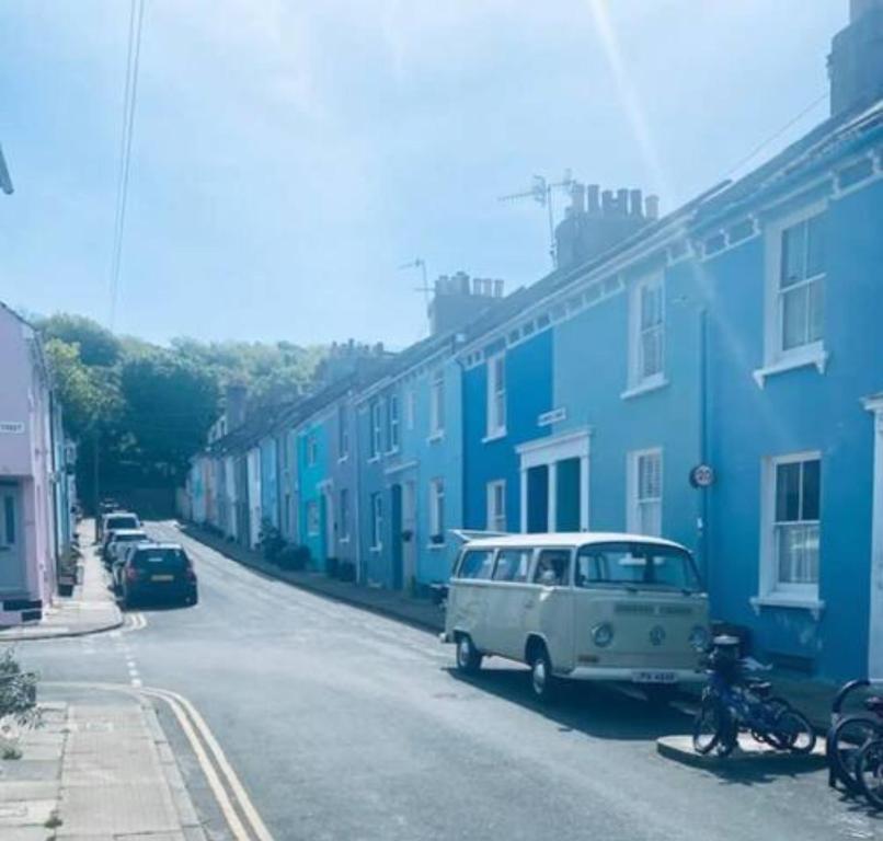una furgoneta blanca estacionada en una calle con casas azules en Hendon Street Beach Huts en Brighton & Hove