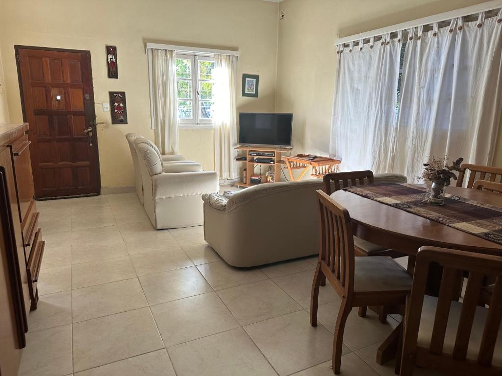 uma sala de estar com um sofá e uma mesa em Casa Los Rosales, amplia, cómoda, excelente ubicación con cochera em Puerto Madryn