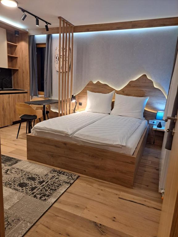 a bedroom with a large bed and a table at Aparthotel Vucko Jahorina NEW 451 in Jahorina