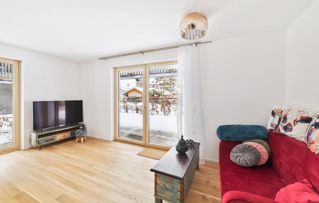 ein Wohnzimmer mit einem roten Sofa und einem TV in der Unterkunft Nice Apartment In Mittenwald With Wifi in Mittenwald