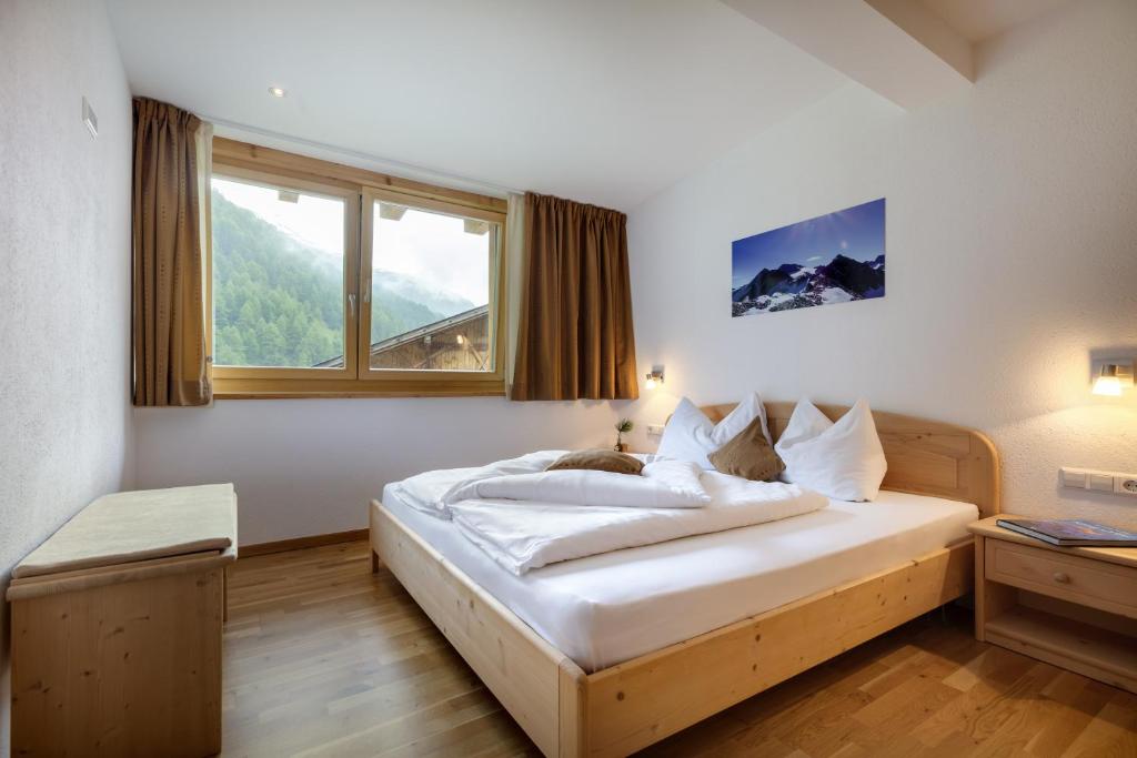 - une chambre avec un grand lit blanc et une fenêtre dans l'établissement Ausserglieshof Wohnung Weißkugel, à Malles Venosta