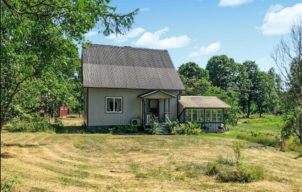 een klein grijs huis in een veld met bomen bij 3 Bedroom Lovely Home In Knred in Knäred