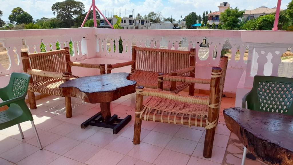 een groep stoelen en tafels op een patio bij ZARADISE SUITES HOTEL, MOMBASA KENYA in Mombasa