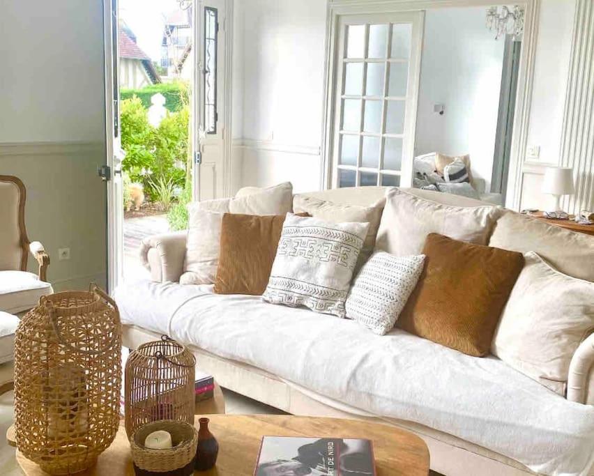 un canapé blanc dans un salon avec une table dans l'établissement Deauville. Grande villa, plage., à Tourgéville