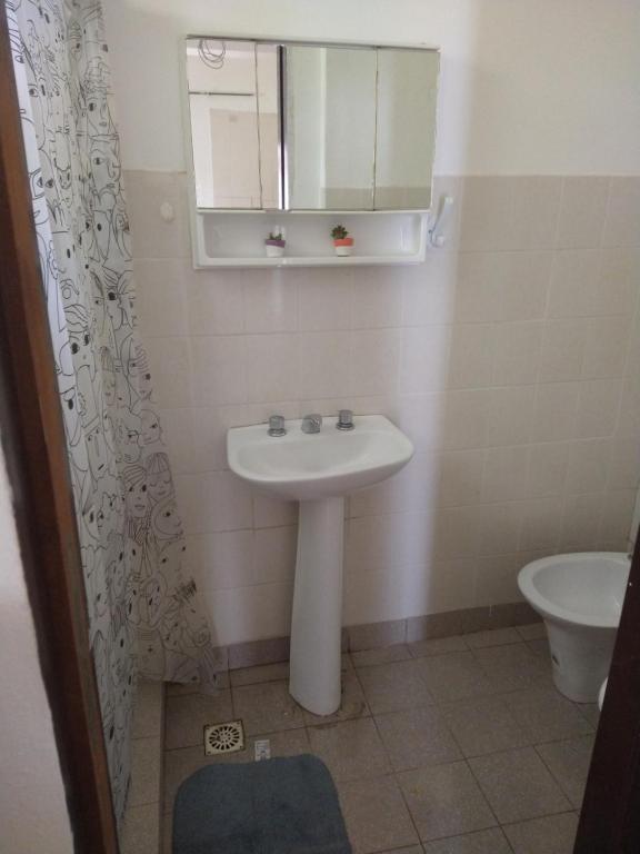 a bathroom with a sink and a mirror and a toilet at Lugar de descanso LA JESUSA in Playa Unión