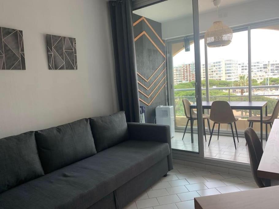un salon avec un canapé et une table dans l'établissement Sur port de Carnon / Palavas charmant petit studio, à Mauguio