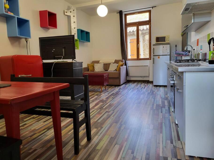 a kitchen and a living room with a table and a kitchen gmaxwell gmaxwell gmaxwell gmaxwell at T2 centre village "Chez Clothilde" in Remoulins