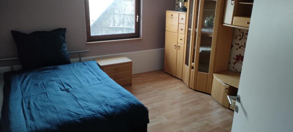 Un dormitorio con una cama y una cómoda y una ventana. en Käfer e, en Waldbrunn