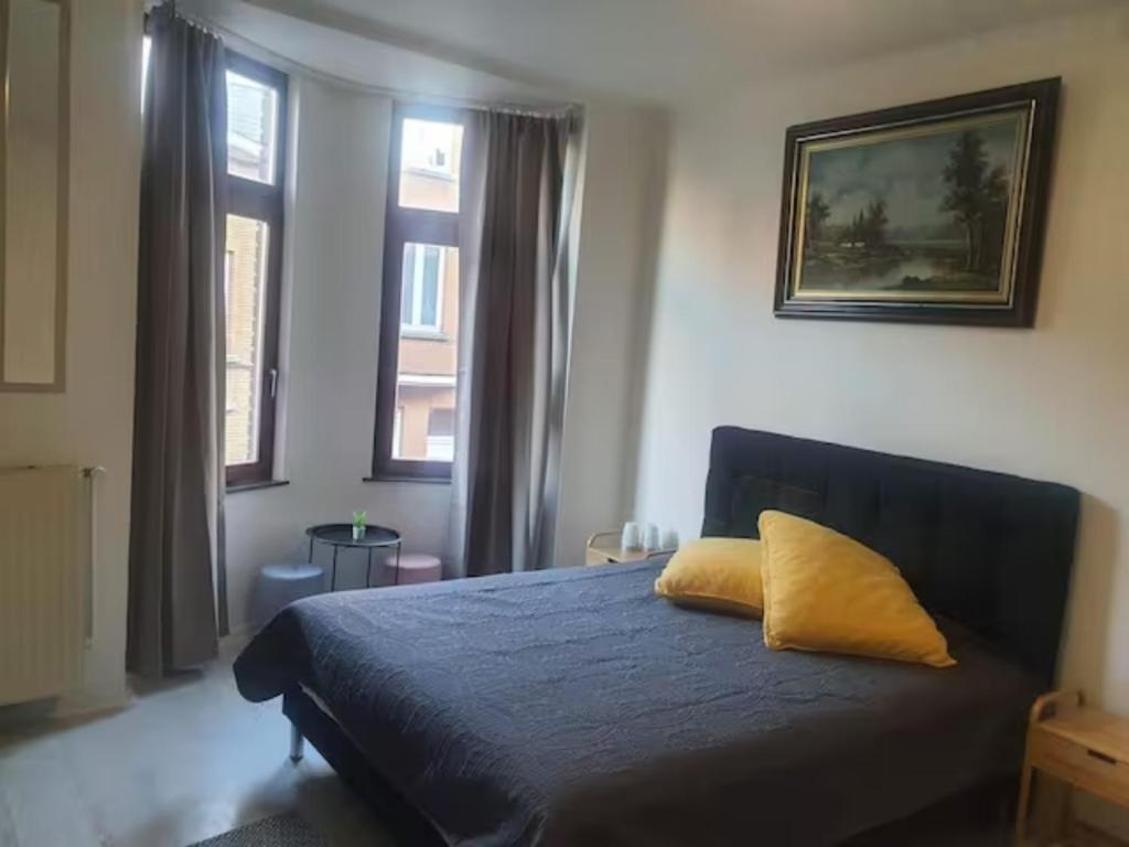 a bedroom with a blue bed with a yellow pillow at Beautiful, renovated fully self contained room in Brussels