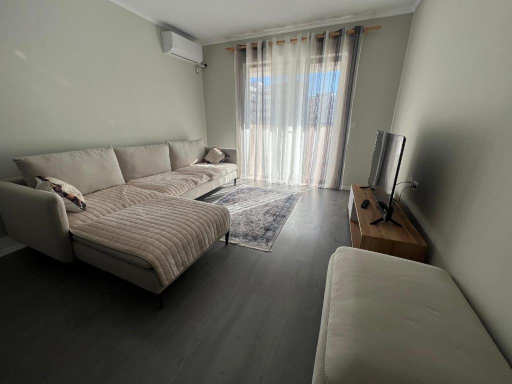 a living room with a couch and a tv at Brand new condo for rent in Tirana