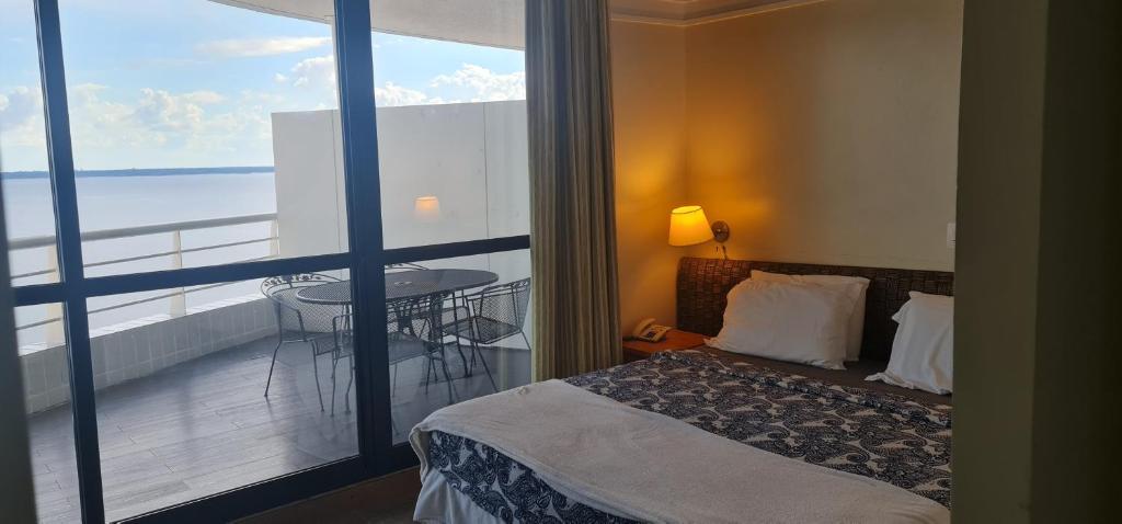 Un pat sau paturi într-o cameră la Cobertura Alto luxo Tropical hotel
