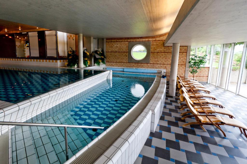 a large swimming pool with chairs in a building at Ramsauhof in Ramsau am Dachstein