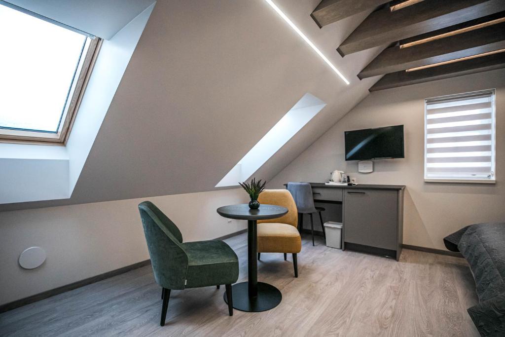 a loft room with a desk and a bed and a table at Senamiesčio apartamentai in Anykščiai
