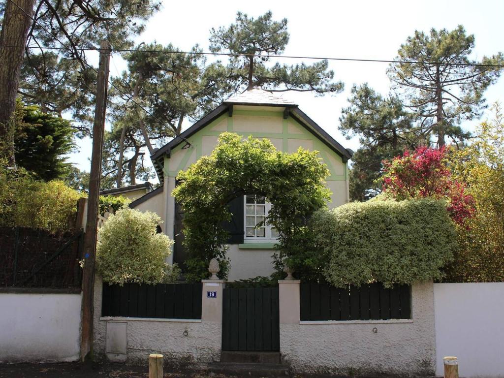 een wit huis met een hek en struiken bij Maison La Baule, 2 pièces, 4 personnes - FR-1-245-115 in La Baule